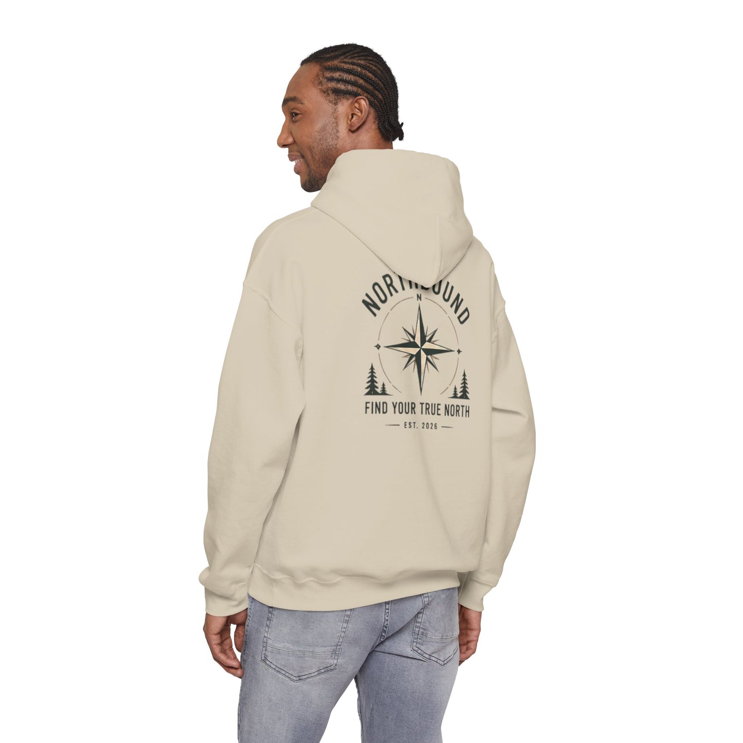Person wearing a beige hoodie with a graphic design on the back, standing against a white background