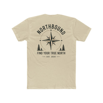 A light beige crewneck t-shirt shown from the back, featuring a black graphic print with a compass rose, pine trees, and the text 'NORTHBOUND' and 'FIND YOUR TRUE NORTH EST. 2026'.