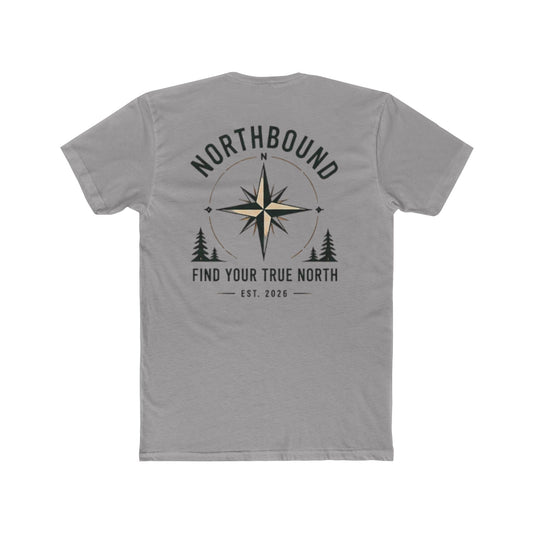 A gray short-sleeve t-shirt shown from the back, featuring a dark gray graphic print with a compass rose, pine trees, and the text 'NORTHBOUND' and 'FIND YOUR TRUE NORTH EST. 2026'.